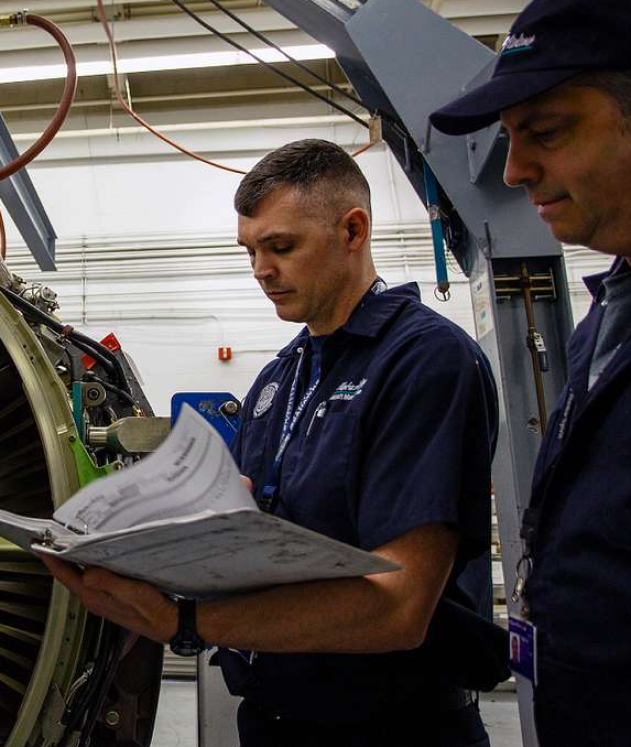 Technician performing routine maintenance on a defibrillator to ensure it's ready for emergencies.}